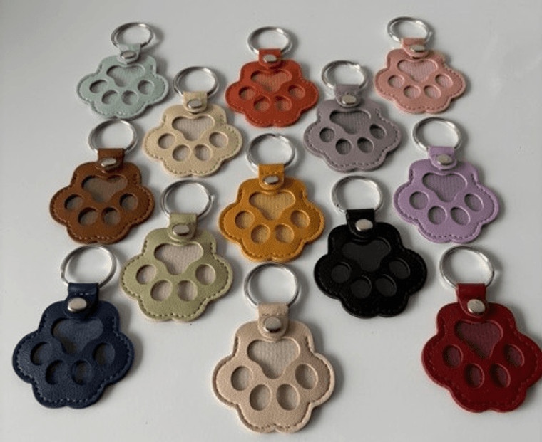 paw-shaped leather key chains in a range of colors, each with paw print cutouts over a mesh window