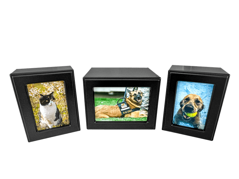 three matte black photo urns holding pictures of a cat, a K-9 shepherd, and a retriever